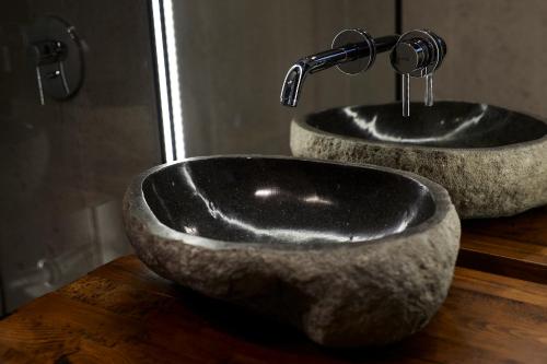 a bathroom with two stone sinks on a wooden counter at New Port Aparthotel in Kraków