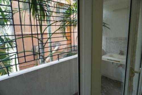 a bathroom with a glass door with a sink and a mirror at RBS NEST in Tiruchchirāppalli