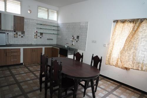 a kitchen with a table and chairs in a room at RBS NEST in Tiruchchirāppalli
