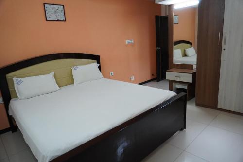a bedroom with a large bed and a mirror at RBS NEST in Tiruchchirāppalli