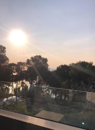 a view of the sun setting over a fence at Apartment Deni in Pula
