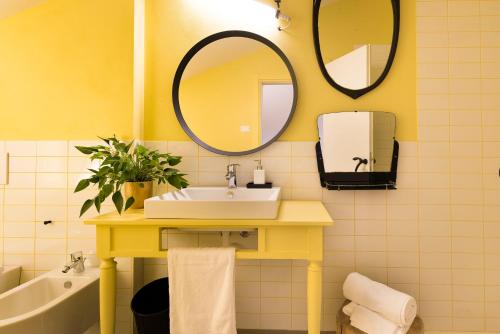 a yellow bathroom with a sink and a mirror at Gabanel Bike Hostel in Bussolengo