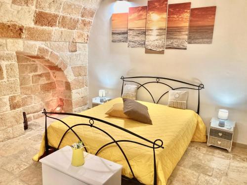 a bedroom with a bed and a brick wall at Antica Pietra in Polignano a Mare