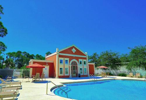 un bâtiment avec une piscine en face d'une maison dans l'établissement Our Happy Place, à Destin