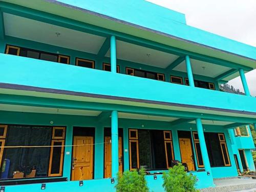 a blue house with blue columns at Aman Resort, Tosh Village, Himachal Pradesh in Tosh