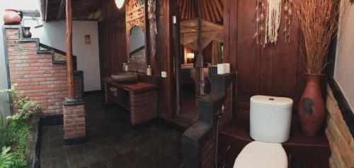 a bathroom with a white toilet in a room at Kubu Kangin Resort in Amed