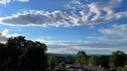 a blue sky with clouds above a house at Café Ilse - Ferienwohnungen in Ranis