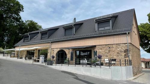 a building with a black roof on a street at Café Ilse - Ferienwohnungen in Ranis