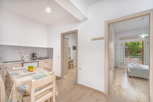 a kitchen and a dining room with a table and a table and chairs at Pyrgaraki Studios and Apartments in Vasilikos