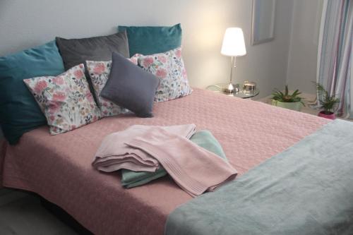 łóżko z różowym kocem i poduszkami w obiekcie Ricardo Rolão Vista Mar - Edifício Oásis - Bedrooms w Faro