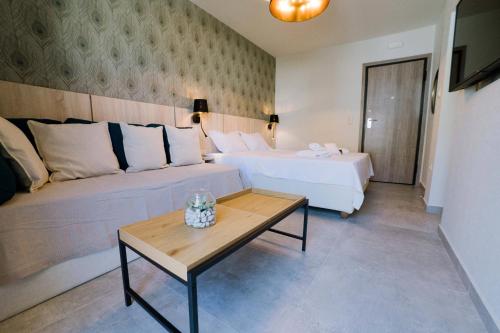 a hotel room with two beds and a table at Loutraki hidden Gem II in Loutraki