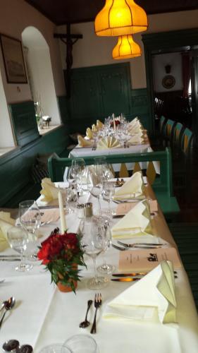 a long table with white plates and wine glasses at Gasthof - Hotel zur Post in Pöcking