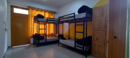 a room with three bunk beds and a door at Whoopers Hostel Kasol in Kasol