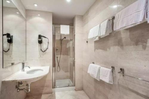 y baño con lavabo y ducha. en Rome Airport Hotel Fiumicino, en Fiumicino