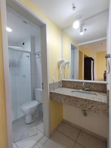 uma casa de banho com um WC, um lavatório e um espelho. em City Bauru Reserve Agora em Bauru