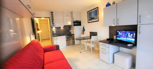a living room with a red couch and a kitchen at STUDIO PORT VAUBAN excellente situation climatisé Box Fibre in Antibes