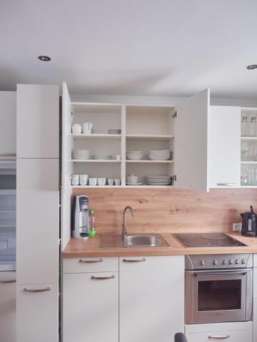 a kitchen with white cabinets and a sink at Ferienwohnung zur lustigen Gabi in Thiersee