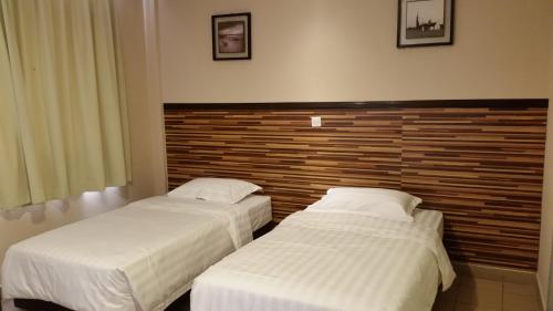 zwei Betten nebeneinander in einem Zimmer in der Unterkunft Hotel Sri Iskandar in Kota Kinabalu