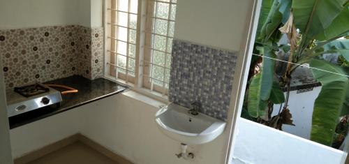 Jestine Homestay في كوتشي: حمام مع حوض ونافذة