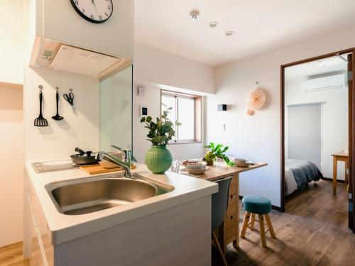 a kitchen with a sink and a mirror at Home n Lounge in Tokyo