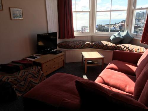 a living room with a couch and a tv at Lammas Park House in Dawlish