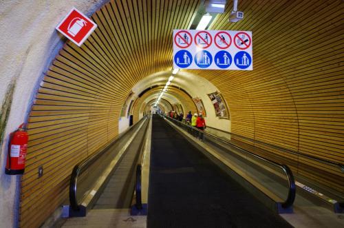 a hallway of a subway tunnel with people on the escalators at Villa Hubertus in Ortisei