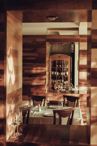 a dining room with a table with chairs and a mirror at Denisa Boutique in Poiana Brasov