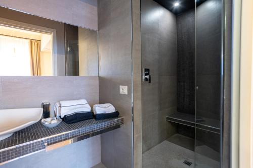 a bathroom with a sink and a glass shower at Cardilli Luxury Rooms in Rome