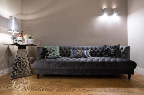 a black couch in a living room with a table at Cardilli Luxury Rooms in Rome