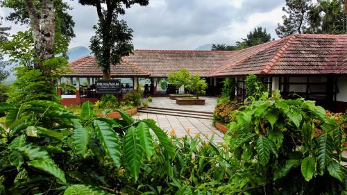 a building with a courtyard with trees and plants at Pranavam Resort & Spa in Tariyod