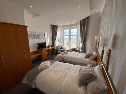 a hotel room with two beds and a television at The Strand Hotel in Blackpool
