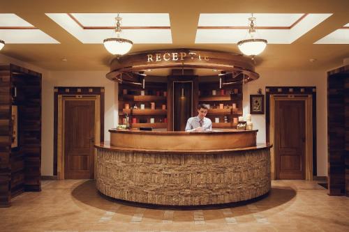 a man standing behind a bar at a hotel at Denisa Boutique in Poiana Brasov