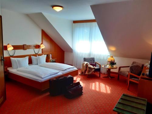 Habitación de hotel con cama, mesa y sillas en Gasthaus Auerhahn en Baden-Baden