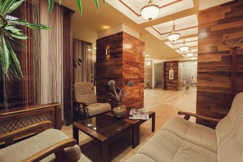a living room with two chairs and a table at Denisa Boutique in Poiana Brasov