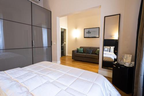 a bedroom with a large white bed and a couch at Cardilli Luxury Rooms in Rome
