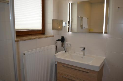 bagno con lavandino e specchio di Gasthof Alte Tanne a Hof bei Salzburg