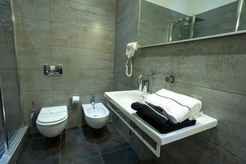 a bathroom with a white sink and a toilet at Cardilli Luxury Rooms in Rome