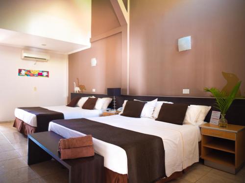 a hotel room with two beds in a room at Palma Real Posada in Puerto Iguazú