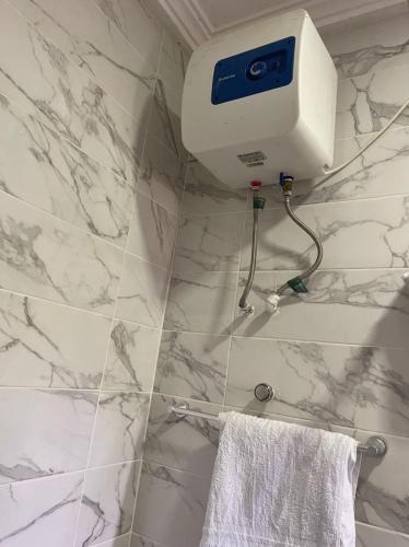 a bathroom with white marble walls and a towel at Bonsukoda Lodge in Accra