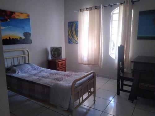 um quarto com uma cama e um piano em Casa Amarela em Uberlândia