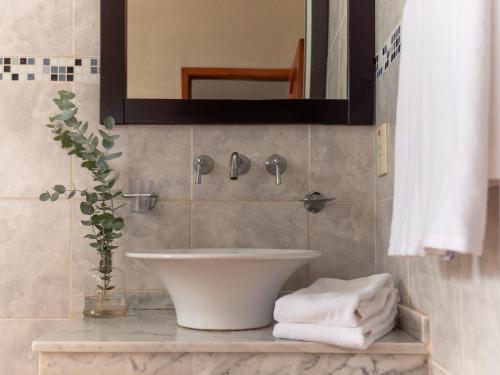 a bathroom with a sink and a mirror and towels at Palma Real Posada in Puerto Iguazú