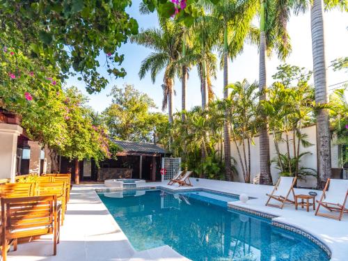 una piscina con sillas y palmeras en Palma Real Posada en Puerto Iguazú