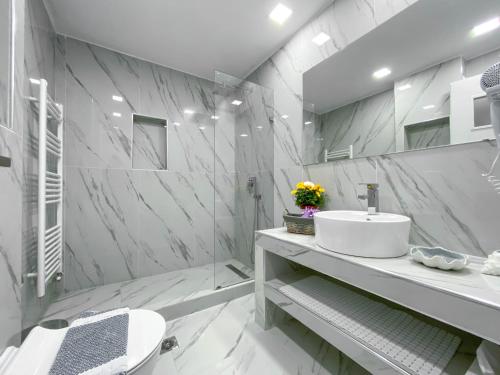 bagno bianco con lavandino e specchio di Diamond Luxury Villa Corfu 5 Bedroom Luxury Villa a Mesongi