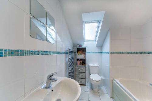 a white bathroom with a sink and a toilet at Stylish Townhouse with views of Arundel Cathedral in Arundel