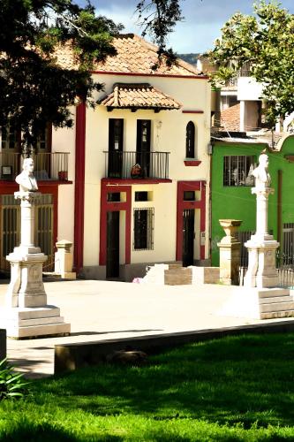 a house with two statues in front of it at Hotel Aroma del Bosque Posada Cafe in Tunja