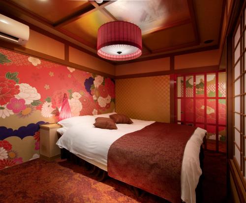 a bedroom with a bed and a painting on the wall at Hotel Benkyo Beya Amagasaki in Amagasaki