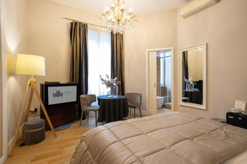 a bedroom with a bed and a table and a television at Cardilli Luxury Rooms in Rome