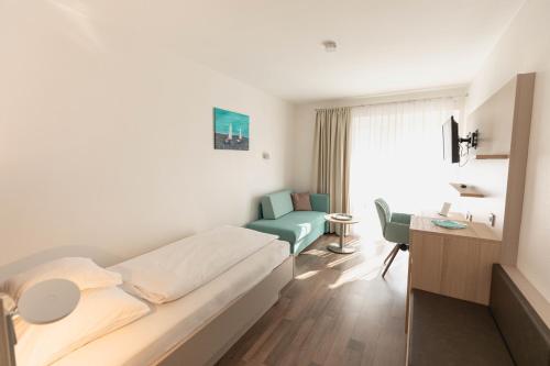 a hotel room with a bed and a desk at Hotel Christine in Radolfzell am Bodensee
