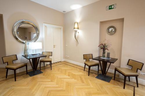 a room with two tables and chairs and a mirror at Cardilli Luxury Rooms in Rome