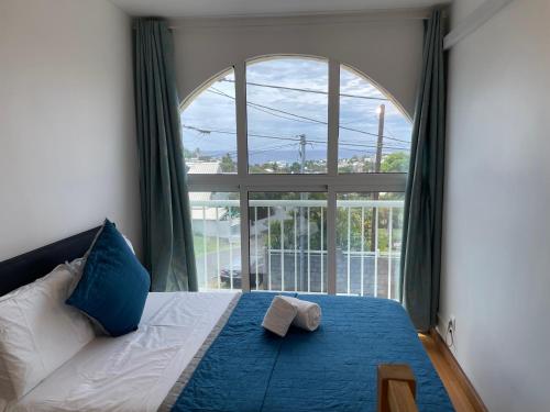 a bedroom with a bed with a large window at La Villa Des Pêcheurs in Filaos